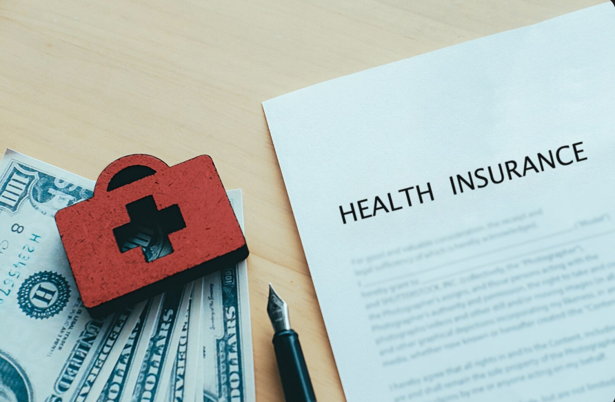 Health insurance policy and cash illustrating how insurance deductibles work in practice