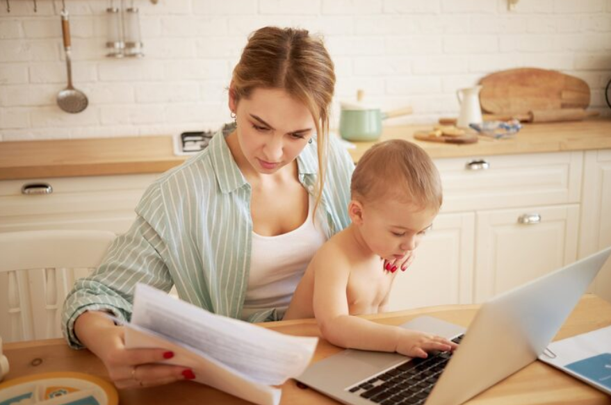 parent with baby reviewing insurance changes at home